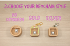 Three keychain options on a wooden surface with 'No Keychain', 'Gold', and 'Silver' text.